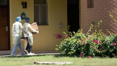 Two members of Red Crescent deliver meals for isolated people following the coronavirus disease (COVID-19) outbreak at Khairan Resort, used as a quarantine centre, in Khairan, Kuwait. Reuters