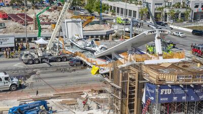Emergency personnel works on a collapsed pedestrian bridge. Giorgioa / EPA