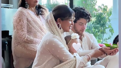 Nick Jonas and Priyanka Chopra perform a puja as Malti Marie and Madhu Chopra look on.