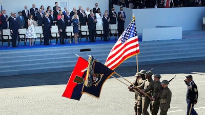 U.S. troops in First World War military clothing march past French president Emmanuel Macron, his wife Brigitte Macron, US president Donald Trump and First Lady Melania Trump. Charles Platiau / Reuters