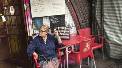A woman sits outside a cafe under Brixton Arches. Once regeneration work is done around 50 small businesses and up to 150 jobs are likely to be lost as the new rents become unaffordable. Dan Kitwood / Getty