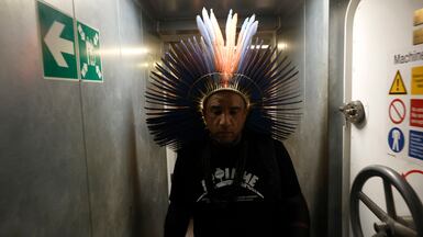 An indigenous member of the Tuxa people walks inside a Greenpeace NGO vessel in Belem, Brazil. EPA