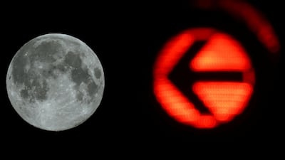It's right there: A traffic light points the way to the supermoon in Frankfurt, Germany. Reuters