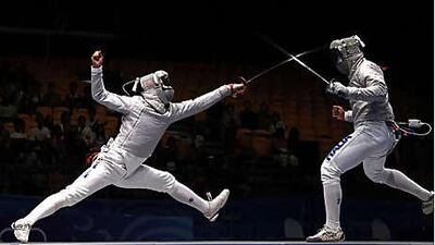 Song Jong Hun of the Repubilc of Korea, left, lunges at Leonardo Affede during the cadet male individual sabre final at the Youth Olympics in Singapore yesterday. Song won the gold medal after defeating Affede 15-8. Zhang Chuanqi / AFP