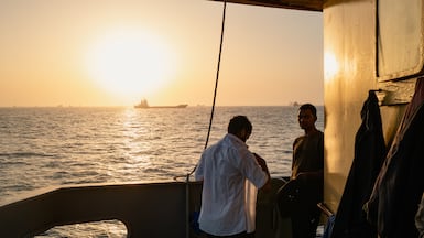 Sailors on a cargo vessel near Oman's Port Sultan Qaboos. Strait of Hormuz traffic has improved, but safety concerns remain. Getty Images