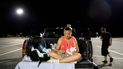 Lorrainda sits with her son in a parking lot. AP Photo