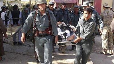 Afghan policemen carry the body of a civilian after a bomb blast in Faryb province killed at least 42 people at a mosque in Afghanistan's relatively peaceful northern region, police officials said.