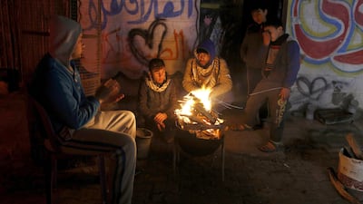 Palestinians, who get only several hours of electricity a day, sit around a fire outside their home in Gaza City. Israel said on April 27, 2017, that it was informed that the Palestinian self-rule government in the West Bank will stop paying for electricity Israel sells to the Gaza Strip. Hatem Moussa / AP Photo File