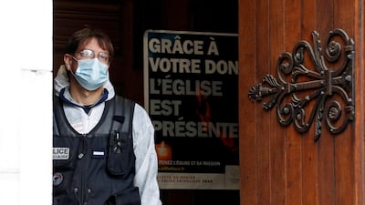 A police officer stands at the entrance of the Notre Dame church. AP Photo
