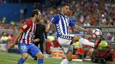 Atletico Madrid's Juanfran, left, fights for the ball with Alaves's Edgar Mendez. (Juan Carlos Hidalgo/EPA)