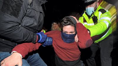 Police officers restrain a woman at a vigil for Sarah Everard held on Clapham Common, south-west London. AFP