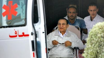 Former Egyptian President Hosni Mubarak, 85, is escorted by medical and security personnel into an ambulance. AP Photo/Amr Nabil