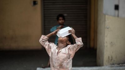 A Malaysian homeless child eats food on a street in Kuala Lumpur. Mohd Rasfan / AFP