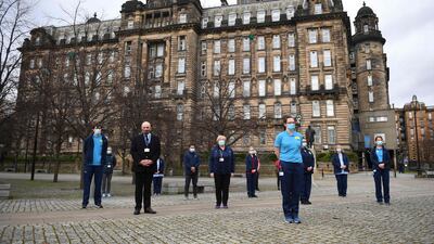 Health workers from the Glasgow Royal Infirmary take part in a minutes silence. AFP