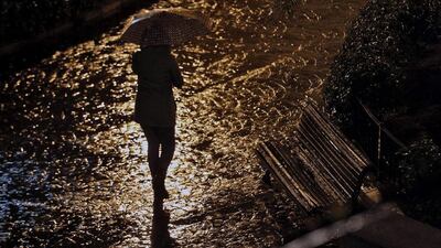 A woman walks in the rain in Valencia, eastern Spain. Manuel Bruque / EPA