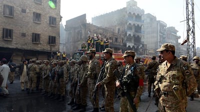 Pakistani soldiers keep watch as Sunni Muslims demonstrate in front of a burnt mosque following sectarian clashes in Rawalpindi. Farooq Naeem / AFP