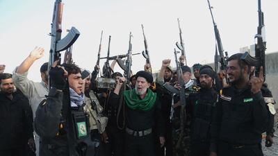 Iraqi Shiite militia group called Imam Ali Brigades chant slogans against ISIS on a battlefield in Tikrit, 130 kilometres north of Baghdad. AP, file