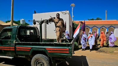 A Sudanese soldiers gestures as locals await the arrival of Sudan's prime minister in El-Fasher, the capital of the North Darfur state. AFP