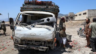 People inspect a damaged truck at a vegetable market following a reported airstrike in Idlib, Syria. EPA
