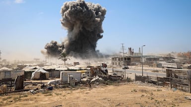 A column of smoke rises behind a camp for Palestinian families in central Gaza. AFP