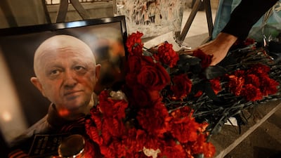 A man lays flowers at the makeshift memorial in Russia in honour of Yevgeny Prigozhin. AFP