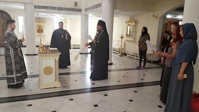 Alexander Zarkeshev, rector of the Russian Orthodox Church in Sharjah, conducts a prayer for the victims. Thaer Zriqat / The National
