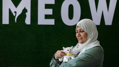 Owner Nehma Maabad holds a feline at her newly inaugurated Cat Cafe in Gaza City on August 17, 2023. (Photo by MOHAMMED ABED / AFP)