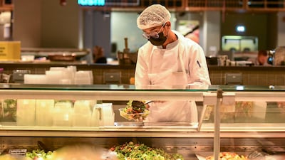 A worker serves salad at Lulu Hypermarket, Abu Dhabi. Khushnum Bhandari / The National