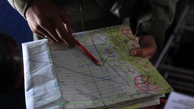 A pilot of a Royal Malaysian Air Force CN-235 aircraft shows a map during a search and rescue operation for the missing Malaysia Airlines plane over the waters at Malacca straits, Malaysia. Lai Seng Sin / AP Photo