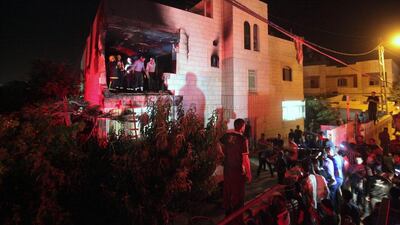 People gather at the partially burned home of Amar Abu Eisha, one of the two suspects wanted for the kidnapping and murder of three Israeli teenagers, after the Israeli army set fire to the building in the West Bank village of Halhoul, near Hebron. The two suspects are still at large. Abed Al Hashlamoun/EPA
