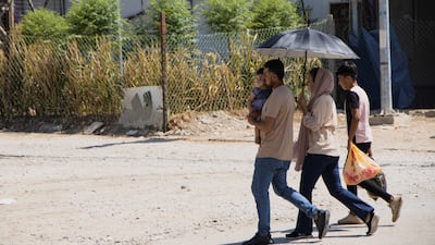 People walk through a camp hosting Syrian refugees in Duhok, in Iraq's Kurdistan Region. Getty Images