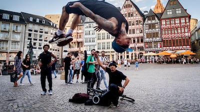 A street artist from Venezuela performs a somersault at Roemerberg square in Frankfurt, Germany. AP