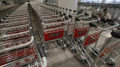 A man pastes advertisements on trolleys at the new terminal of Noi Bai international airport. Kham / Reuters