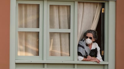 A woman looks out of a window at the H10 Costa Adeje Palace hotel in La Caleta, in the Canary Island of Tenerife, Spain. AP