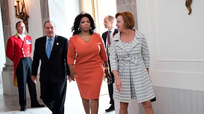 Oprah Winfrey wears an orange shift dress to arrive at Amalienborg Castle, Denmark on October 1, 2009. EPA