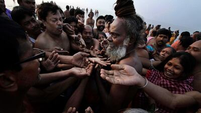 Pilgrims seek blessings from a Hindu holy man at Gangasagar, India.The festival has its roots in a Hindu tradition that says the god Vishnu wrested from demons a golden pot containing the nectar of immortality. Bikas Das / AP Photo