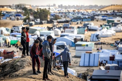 Children stand atop a small hill near tents at a make-shift shelter for Palestinians who fled to Rafah in the southern Gaza Strip. AFP