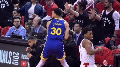 Golden State Warriors guard Stephen Currry, centre, goes out of bounds as rapper Drake, left, moves out of the way. EPA