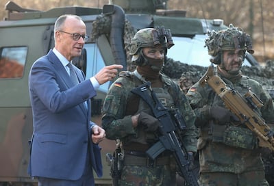 German Chancellor Friedrich Merz, left, with soldiers of the Guard Battalion of the Bundeswehr. Berlin has focused on bigger defence budgets. Reuters