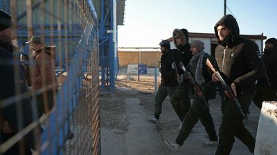 Members of the Syrian security forces march through the entrance of Al Hol. AFP