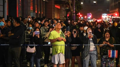 Onlookers gather on the street to watch the operation that involved 250 firefighters and paramedics. AFP