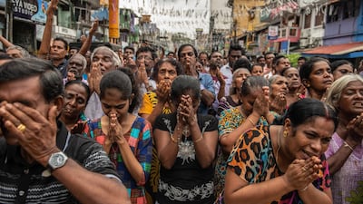 Sri Lankans pray in the street near St Anthony's Shrine a week after the attacks that killed over 250 people. Getty Images