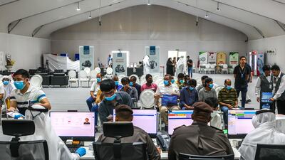 People seek guidance about resolving their expired visa status at tents set up in Dubai's Al Aweer area by UAE immigration authorities