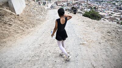 Ballet student Keith Chavez (12) goes down the hill after performing at the San Genaro neighborhood in the Chorrillos district, south of Lima, on April 1, 2023. - At an arid and dry hill in Lima, a group of girls wearing leotards stand on their toes in a rocky and dusty road. Hardly any of them will become a professional dancer, acknowledges without bitterness Maria del Carmen Silva, instructor of the ballet that finances itself from recycling in Peru. (Photo by Ernesto BENAVIDES / AFP)