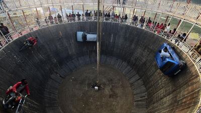 Stuntmen perform a stunt in a "Wall of Death" show at a fairground during the Magh Mela festival in Allahabad. AFP