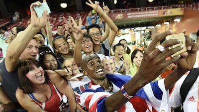 Britain’s Mo Farah poses for ‘selfies’ with supporters after winning the men’s 10,000m run on Saturday at the World Championships in Beijing. Franck Fife / AFP