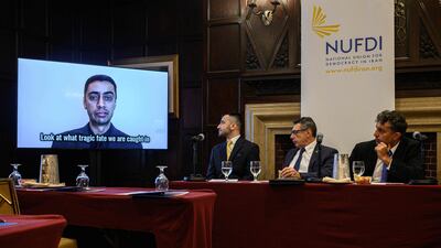 Plaintiff Mehdi Hajati appears on a video monitor during a televised address at a press conference announcing the lawsuit. AFP