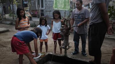 The Balwyut family use a well as they prepare for dinner with their neighbours. He was one of the AMMA's first 12 participants and is learning how to bring up his children in his wife's absence. Jes Aznar for The National