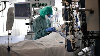 A medical staff member tends to a Covid-19 patient in the ICU of the Clinica Universitaria in Pamplona, northern Spain, on January 12. AP