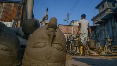 A worker walks near semi-finished clay idols of the Hindu goddess Kali in Siliguri on October 18, 2019. The worship of Hindu deity Kali takes place on October 27 in the eastern Indian states along with 'Diwali', the Festival of Lights, marking the victory of good over evil and commemorating the time when the Hindu god Lord Rama achieved victory over Ravana. AFP